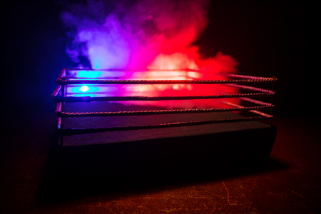 Empty boxing ring with red ropes for match in the stadium arena. Creative artwork decoration. Foggy background with light. Selective focusの写真素材
