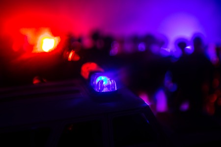 Anti-riot police give signal to be ready. Government power concept. Police in action. Smoke on a dark background with lights. Blue red flashing sirens. Dictatorship powerの写真素材