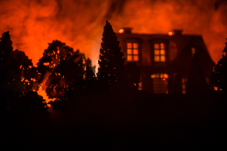 Old house with a Ghost in the forest at night or Abandoned Haunted Horror House in fog. Old mystic building in dead tree forest. Trees at night with moon. Surreal lights. Horror Halloween conceptの写真素材