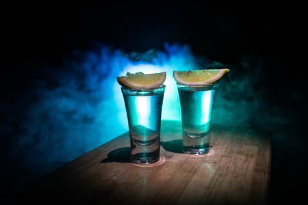 Club drink concept. Tasty alcohol drink cocktail tequila with lime and salt on vibrant dark background or glasses with tequila at a bar. Selective focusの写真素材