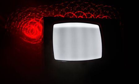 Old vintage red TV with white noise on dark toned foggy background. Retro old Television reciever no signal. Selective focusの写真素材
