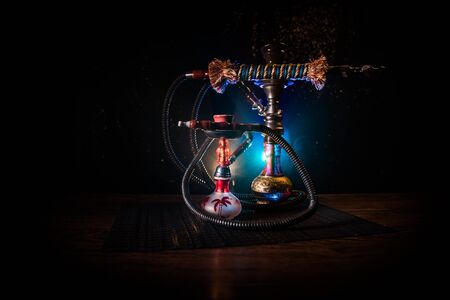 Hookah hot coals on shisha bowl on dark foggy background. Stylish oriental shisha. Creative concept