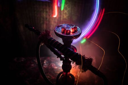 Hookah hot coals on shisha bowl on dark foggy background. Stylish oriental shisha. Creative conceptの写真素材