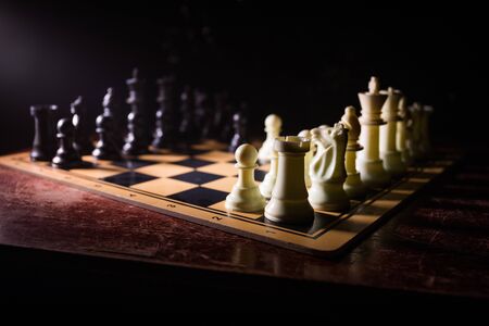 Chess board game concept of business ideas and competition. Chess figures on a dark background with...