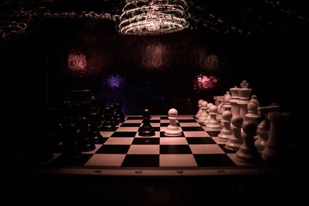 Chess board game concept of business ideas and competition. Chess figures on a dark background with smoke and fog. Selective focusの写真素材