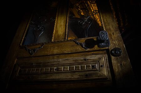 Close up view of old antique wooden door inside a dark room. Selective focus. Horror conceptの写真素材