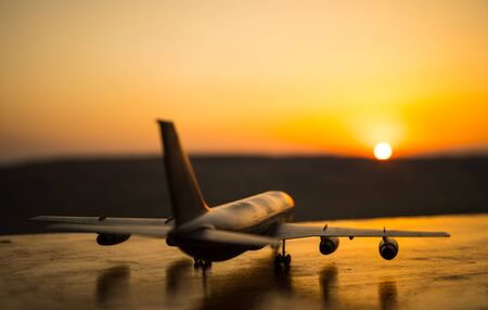 Artwork decoration. White passenger plane ready to taking off from airport runway. Silhouette of Aircraft during sunset time. Selective focusの写真素材
