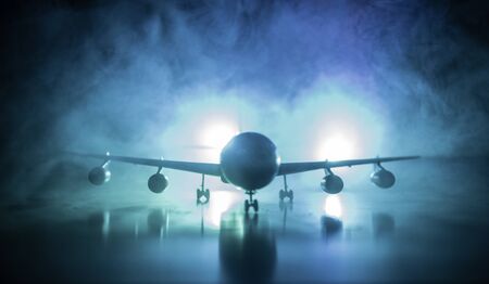 Artwork decoration. White passenger plane ready to taking off from airport runway. Silhouette of Aircraft during night time. Selective focusの写真素材