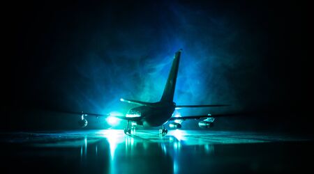 Artwork decoration. White passenger plane ready to taking off from airport runway. Silhouette of Aircraft during night time. Selective focusの写真素材