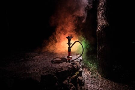 Hookah hot coals on shisha bowl with black background. Stylish oriental shisha at the forest during night timeの写真素材