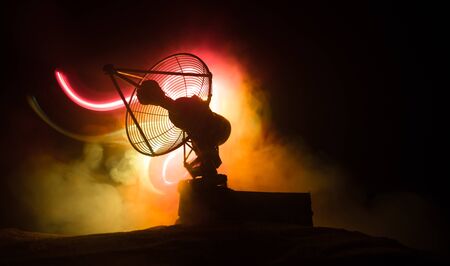 Silhouettes of satellite dishes or radio antennas against night sky. Space observatory or Air defence radar over dramatic night sky. Creative artwork decoration. Selective focusの写真素材