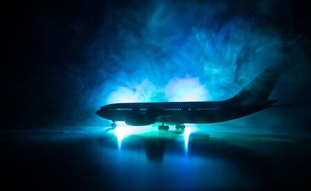 Artwork decoration. White passenger plane ready to taking off from airport runway. Silhouette of Aircraft during night time. Selective focusの写真素材