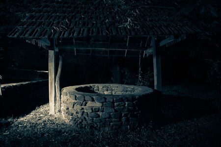 Abandoned well in the forest. Waiting for a terrible girl with a long hair. Halloween concept.の写真素材
