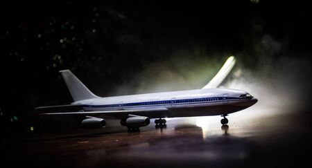 Artwork decoration. White passenger plane ready to taking off from airport runway. Silhouette of Aircraft during night time. Selective focusの写真素材