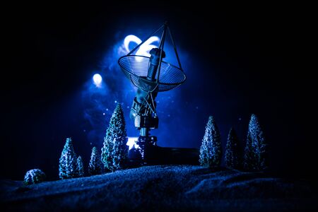 Silhouettes of satellite dishes or radio antennas against night sky. Space observatory or Air defence radar over dramatic night sky. Creative artwork decoration. Selective focusの写真素材