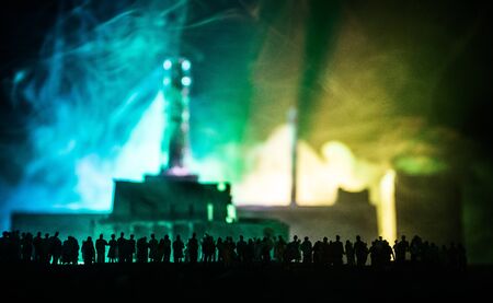 Creative artwork decoration. Chernobyl nuclear power plant at night. Layout of abandoned Chernobyl station after nuclear reactor explosion. Crowd looking on burning reactor. Selective focusの写真素材
