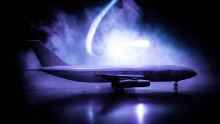 Artwork decoration. White passenger plane ready to taking off from airport runway. Silhouette of Aircraft during night time. Selective focusの写真素材