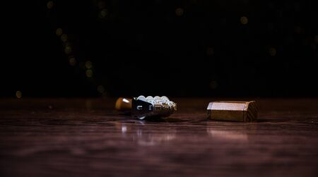 Close up view of rubber date stamper on wooden table with dark toned foggy background. Selective...