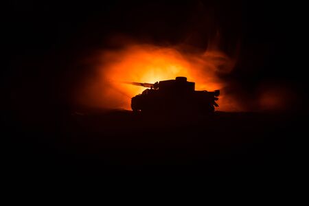 War Concept. Military silhouettes fighting scene on war fog sky background, Silhouette of armored vehicle below Cloudy Skyline At night. Attack scene. Tanks battle. Artwork decorationの写真素材