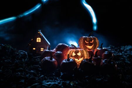 halloween jack-o-lantern on autumn leaves. Scary Halloween Pumpkin looking through the smoke. Glowing, smoking monster pumpkin from depths of hellの写真素材