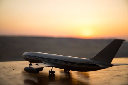 Artwork decoration. White passenger plane ready to taking off from airport runway. Silhouette of Aircraft during sunset time. Selective focusの写真素材