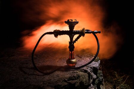 Hookah hot coals on shisha bowl with black background. Stylish oriental shisha at the forest during...