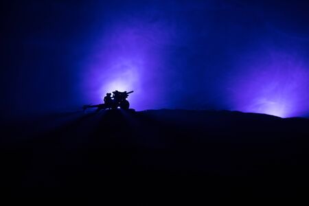 War Concept. Military silhouettes fighting scene on war fog sky background. Attack scene. Armored vehicles and infantry. Creative compositionの写真素材
