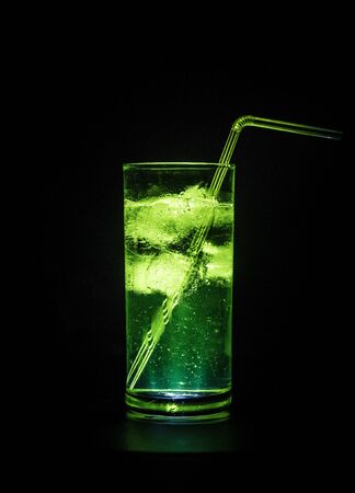 Cocktail glass splashing on dark toned smoky background or colorful cocktail in glass. Party club entertainment. Mixed light. Selective focusの写真素材