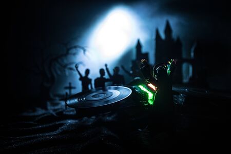 Happy Halloween horror party concept. Scary view of dancing zombies at cemetery with Dj and club lights. Creative artwork decoration. Useful as a party poster or greeting card. Selective focusの写真素材
