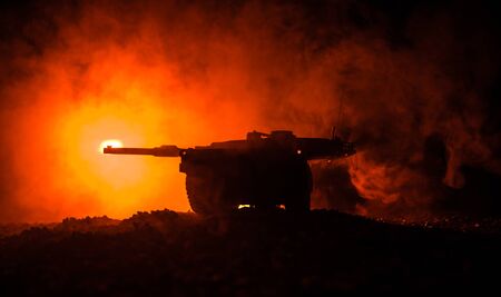 War Concept. Armored vehicle silhouette fighting scene on war foggy sky background at night. American tank ready to fight. Creative decorationの写真素材