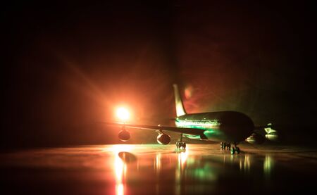 Artwork decoration. White passenger plane ready to taking off from airport runway. Silhouette of Aircraft during night time. Selective focusの写真素材