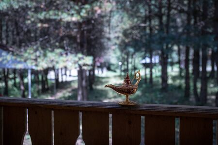 Antique artisanal Aladdin Arabian nights genie style oil lamp at the forest. Lamp of wishes fantasy concept. Selective focusの写真素材