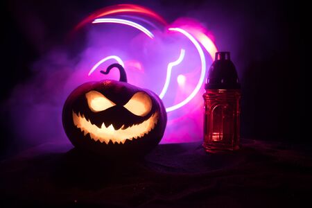 Halloween pumpkin smile and scary eyes for party night. Close up view of scary Halloween pumpkin with eyes glowing inside at black background. Selective focusの写真素材