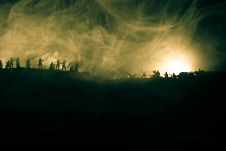 War Concept. Military silhouettes fighting scene on war fog sky background. Attack scene. Armored vehicles and infantry. Creative compositionの写真素材
