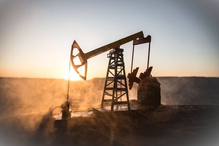 Oil pump and oil refining factory at sunset. Energy industrial concept. Selective focus. Creative artwork decoration.の写真素材