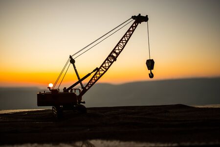 Abstract Industrial background with construction crane silhouette over amazing sunset sky. Mobile crane against the evening sky. Industrial skyline. Selective focusの写真素材