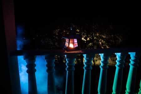 Retro style lantern at night. Beautiful colorful illuminated lamp at the balcony in the garden. Selective focusの写真素材