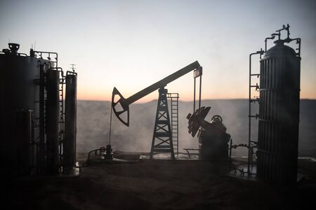 Oil pump and oil refining factory at sunset. Energy industrial concept. Selective focus. Creative artwork decoration.の写真素材