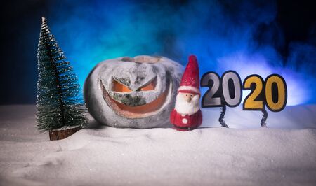 Christmas New Year or Halloween Celebrate Background with Little Christmas Tree and horror pumpkin on snowの写真素材