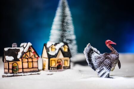 Thanksgiving celebration funny concept. Artwork decoration with Turkey tom statue on snow. Selective focus. Empty space for your textの写真素材