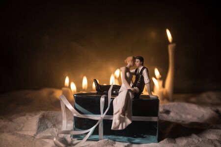 Winter holidays and love concept. Couple doll figures and Christmas decorations on snow with many...