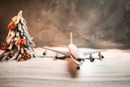 Merry Christmas and Happy new years travel concept background for winter trip. Christmas background with airplane. Creative artwork decoration on snow. Selective focus.の写真素材