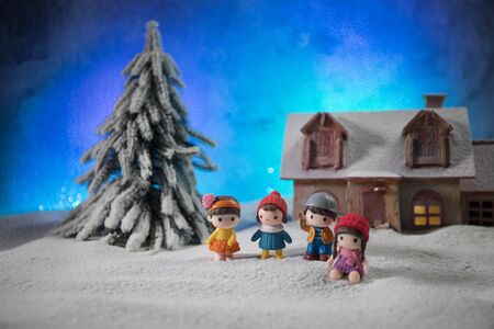 Christmas and New Year holidays concept. Little decorative cute small houses in snow at night. Traditional holiday attributes on snow. Creative artwork decorations. Empty space for your textの写真素材