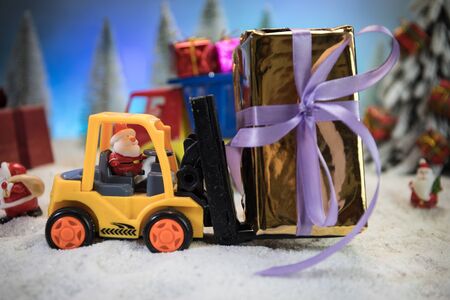 Miniature Gift Box by Forklift Machine on snow ,Determined Image for Christmas Holiday and Happy New...