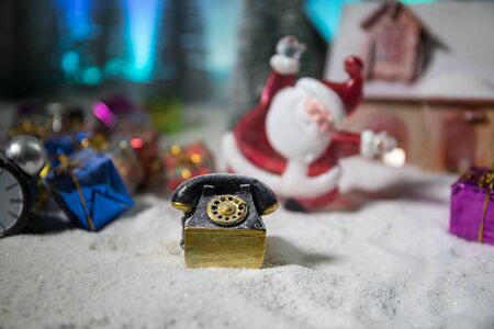 Christmas and New Year holidays concept. Little decorative cute small houses in snow at night. Traditional holiday attributes on snow. Creative artwork decorations. Empty space for your textの写真素材