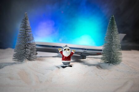 Merry Christmas and Happy new years travel concept background for winter trip. Christmas background with airplane. Creative artwork decoration on snow. Selective focus.の写真素材