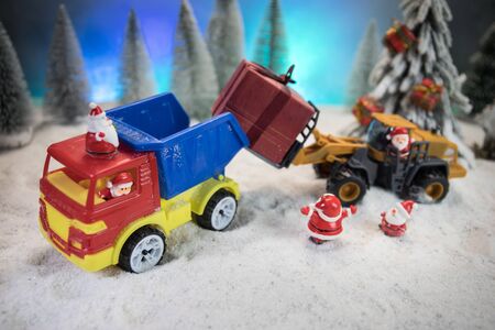 Miniature Gift Box by Forklift Machine on snow ,Determined Image for Christmas Holiday and Happy New Year Gift Celebration concept. Empty space for textの写真素材