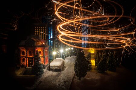 Little decorative cute small houses in snow at night in winter, Christmas and New Year miniature...