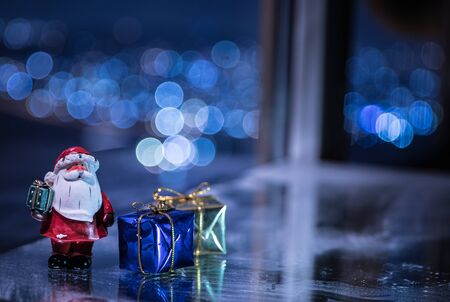Little decorative cute small houses in snow at night in winter, Christmas and New Year miniature house in the snow at night with fir tree. Holiday concept. Selective focusの写真素材