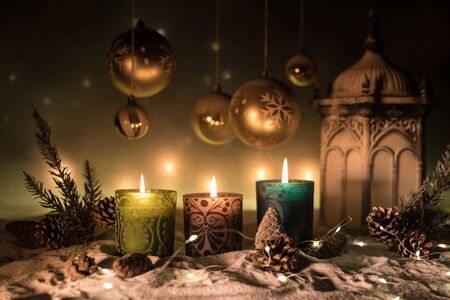 Christmas decoration with burning candles on a dark background. Christmas ornaments over dark golden background with lights. Creative artwork decoration.の写真素材
